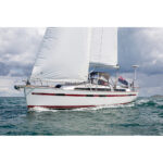 Sailing yacht with white sails on open sea.
