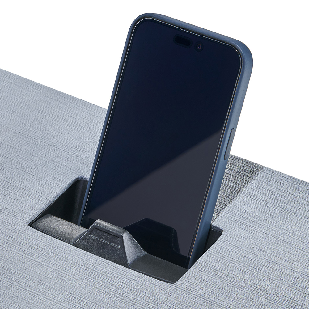 Smartphone charging in desk's built-in holder.