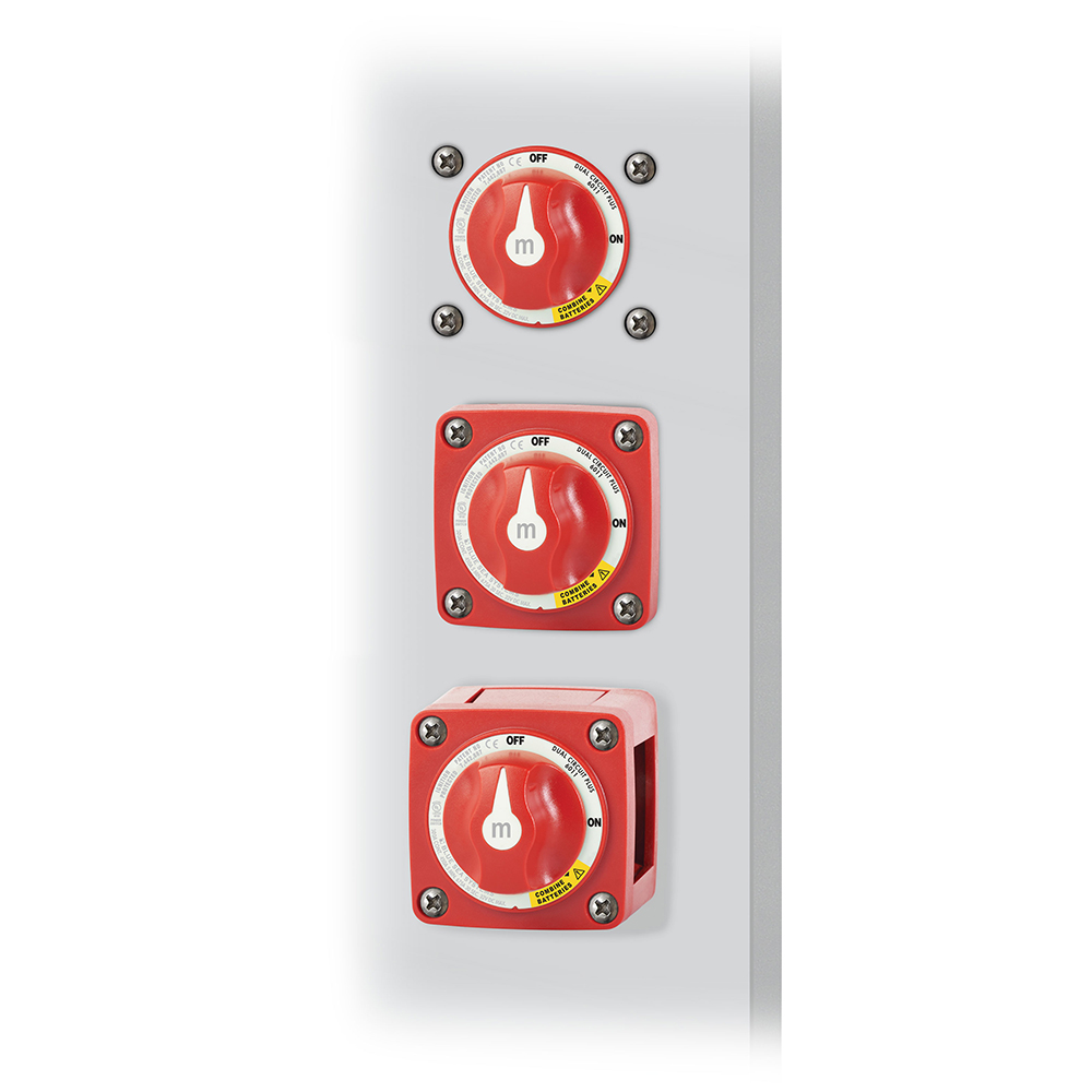 Red electrical disconnect switches stacked vertically on panel.