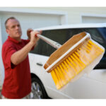 Person washing car with soapy brush