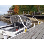 Boat docked by gazebo and autumn trees.
