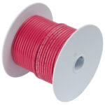 Spool of red electrical wire on white reel.