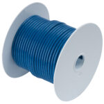 Blue electric wire spool on white background.