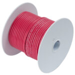 Red electrical wire spool on white background