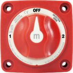 Red marine battery switch with settings and labels.