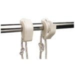 Boat cleats holding ropes on rail