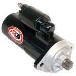 Black automotive starter motor with silver gear.