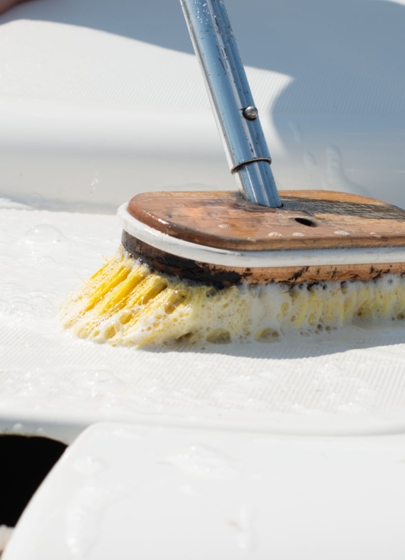 Scrubbing brush cleaning a surface with soap