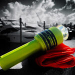 Yellow distress flare next to red cloth on dock.