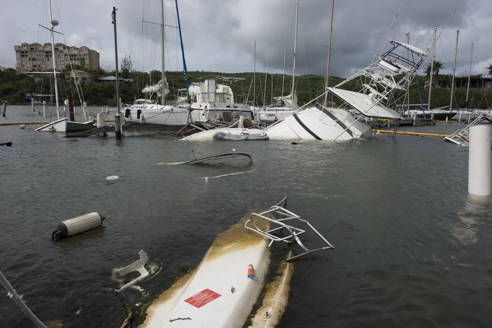 Storm-damaged boats submerged in a flooded marina