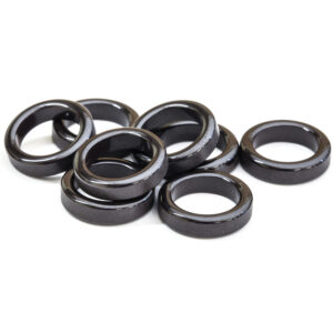 Glossy black ferrite toroidal rings on a white background